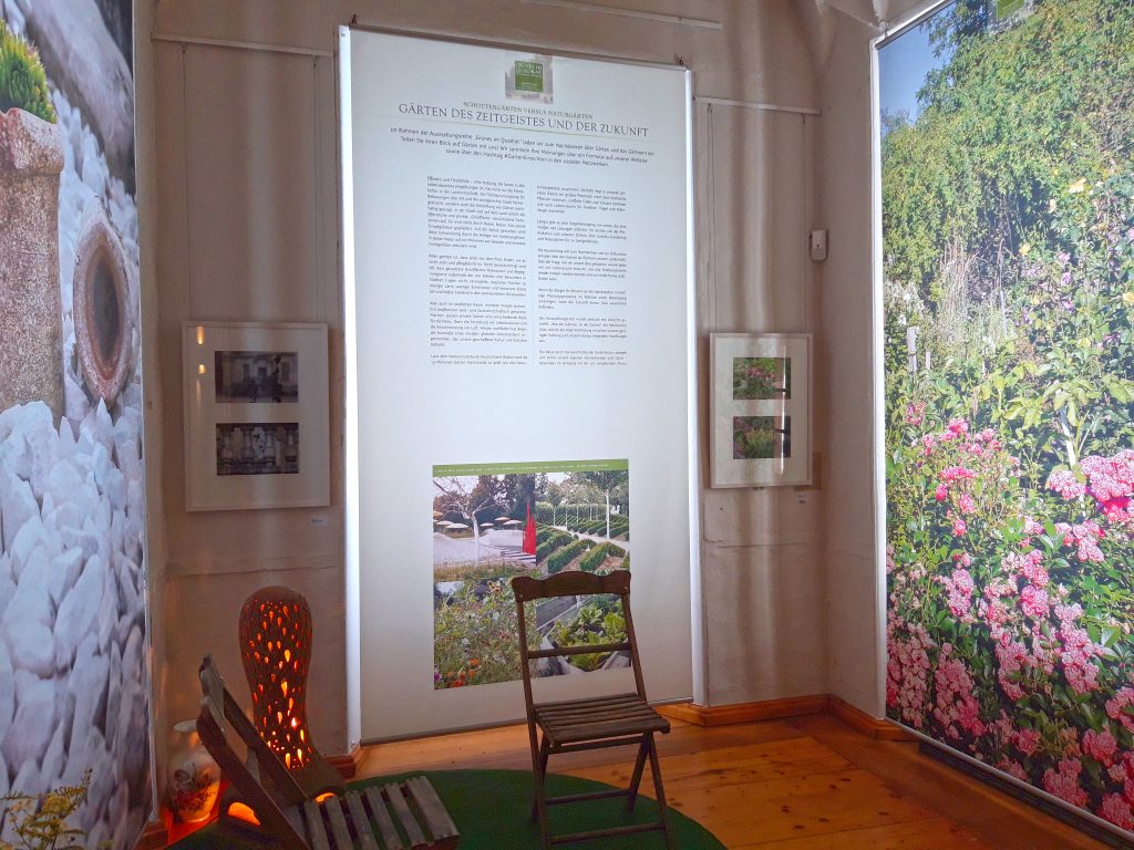 Blick in die Sonderschau #GartenEinsichten im Museum Burg Posterstein - mit zwei Gartenstühlen, Rasenteppich und Gartenmotiven