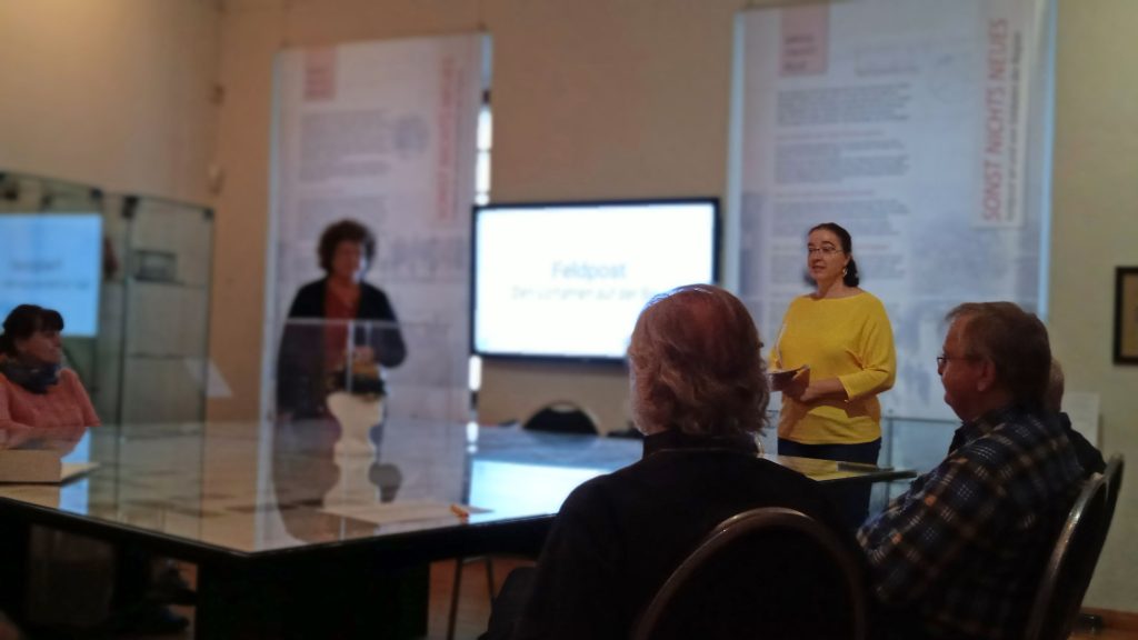 Zwei Frauen vor sitzendem Publikum in der Sonderschau auf Burg Posterstein